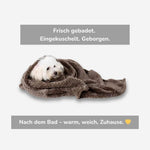 Weißer Hund eingekuschelt in weiche Decke nach dem Baden – warm, geborgen und gemütlich mit HUNDESCHATZ